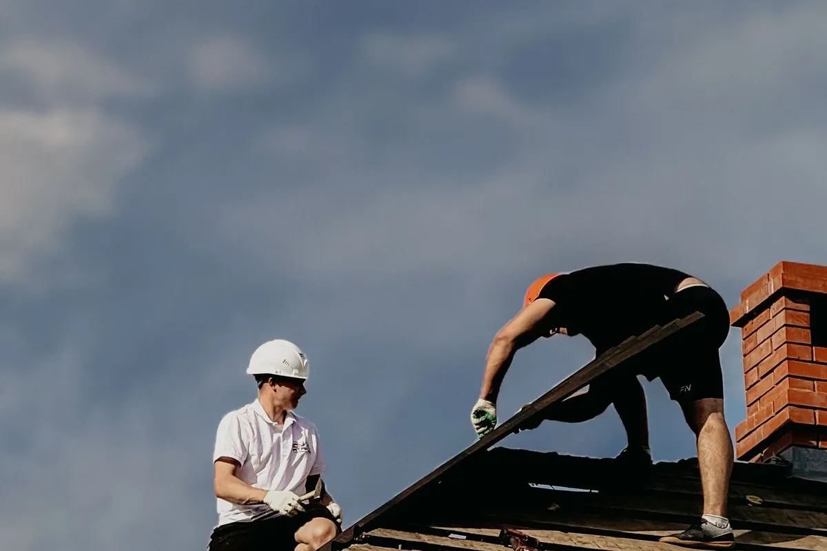 Roofing professionals repairing a residential roof.